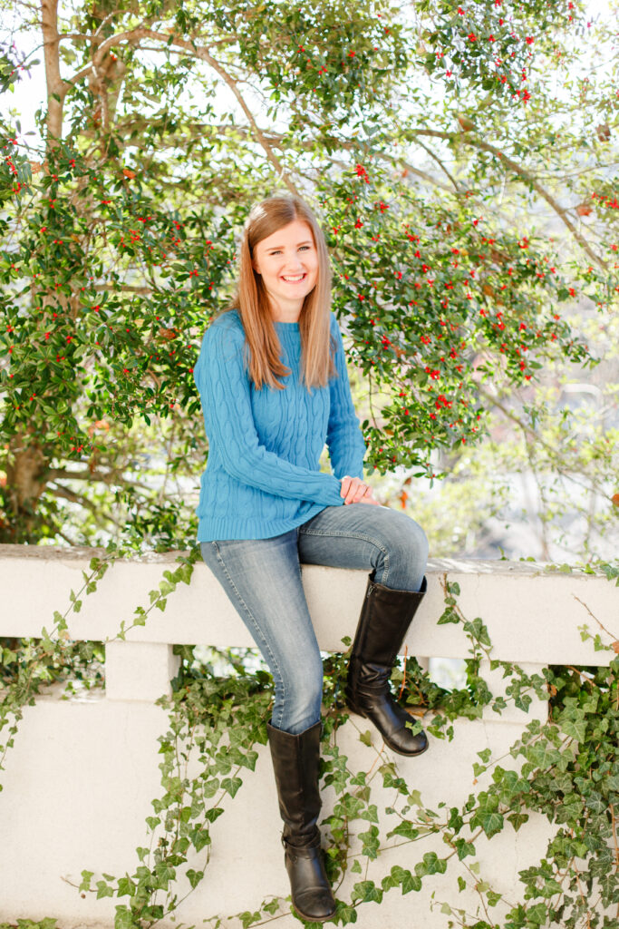 Girl smiles with sitting on wall in Ashville NC. 2023 favorites