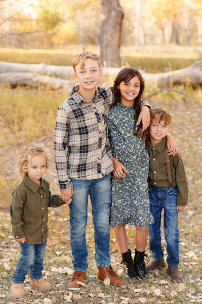 Four siblings hug and hold hands