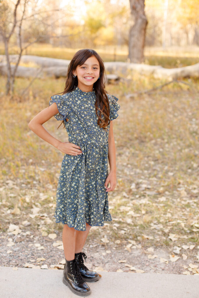 Girl smiles at camera at fall family session 