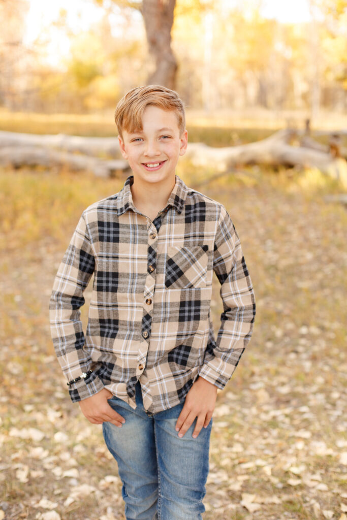 Oldest boy smiles at the camera at fall family session