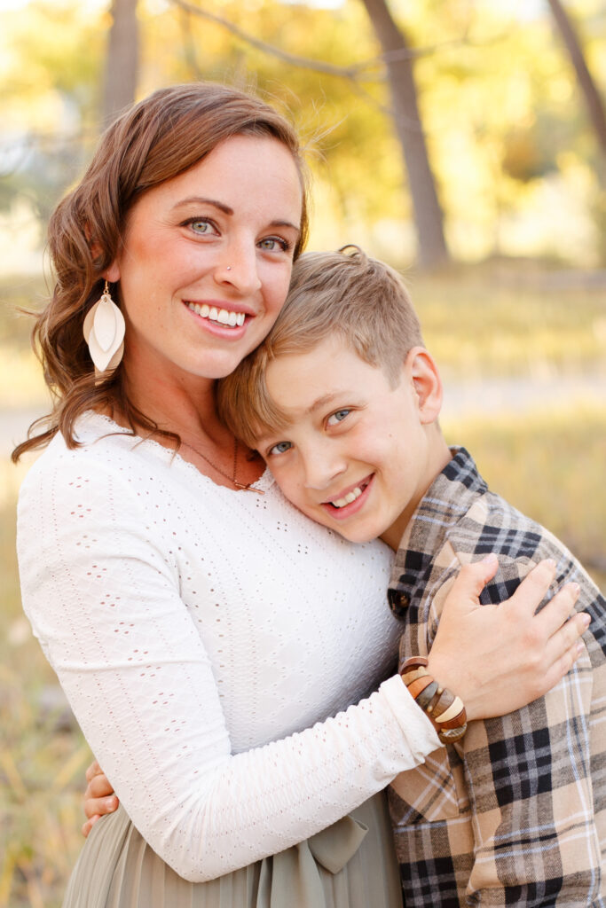 Mom and son hug and smile at family session.