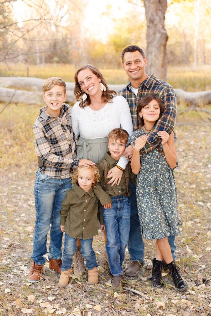 Family of six smiles together at fall family session in Pueblo CO.  2023 favorites