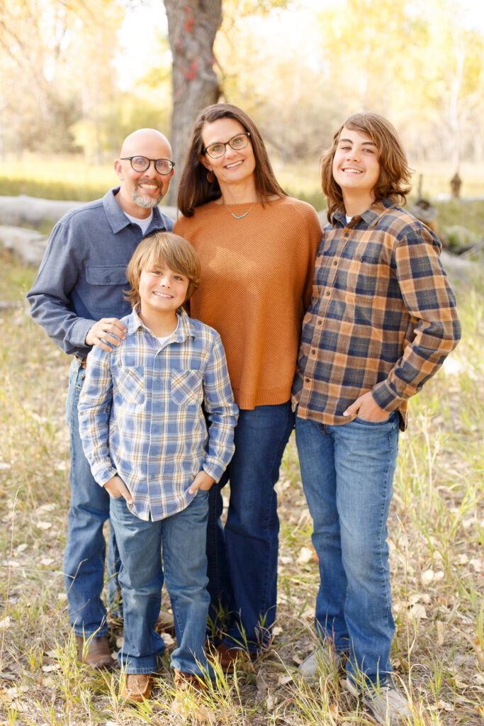 Family stands together and smiles in City Park