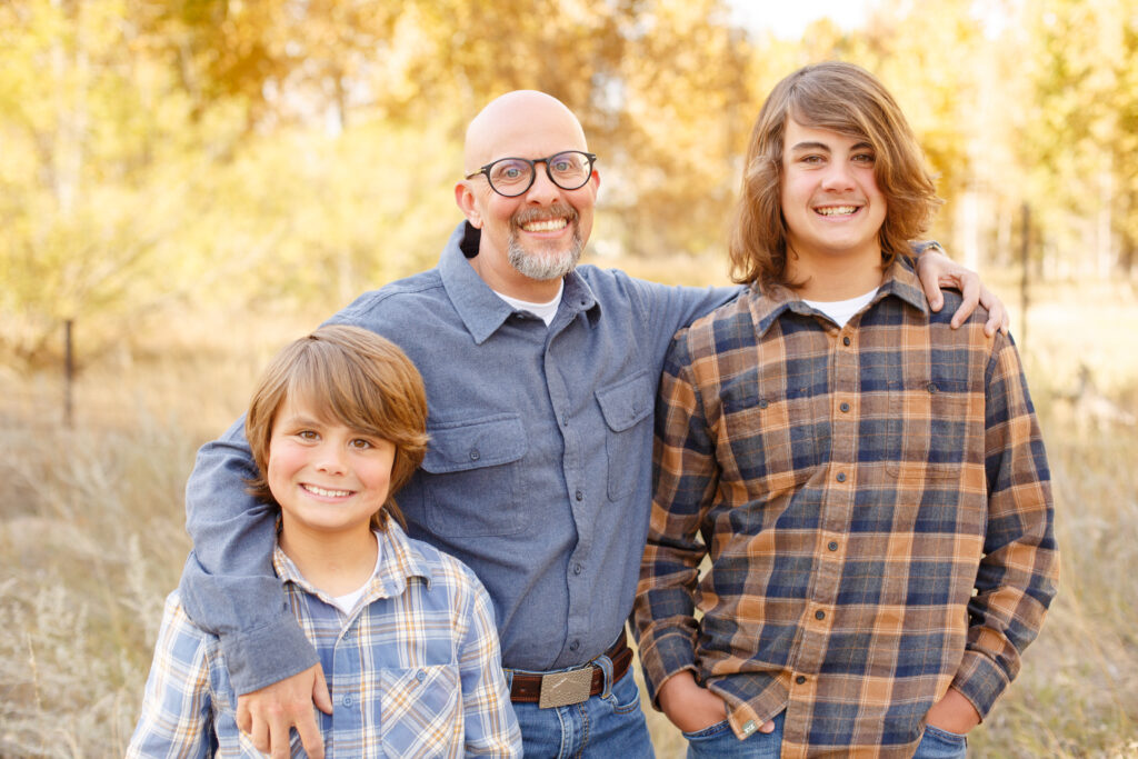 Dad and sons smile at camera in City Park