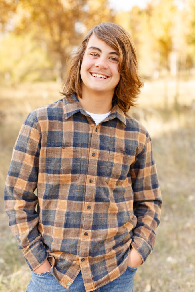 Older boy smiles at camera with hands in pockets in City Park. 2023 favorites