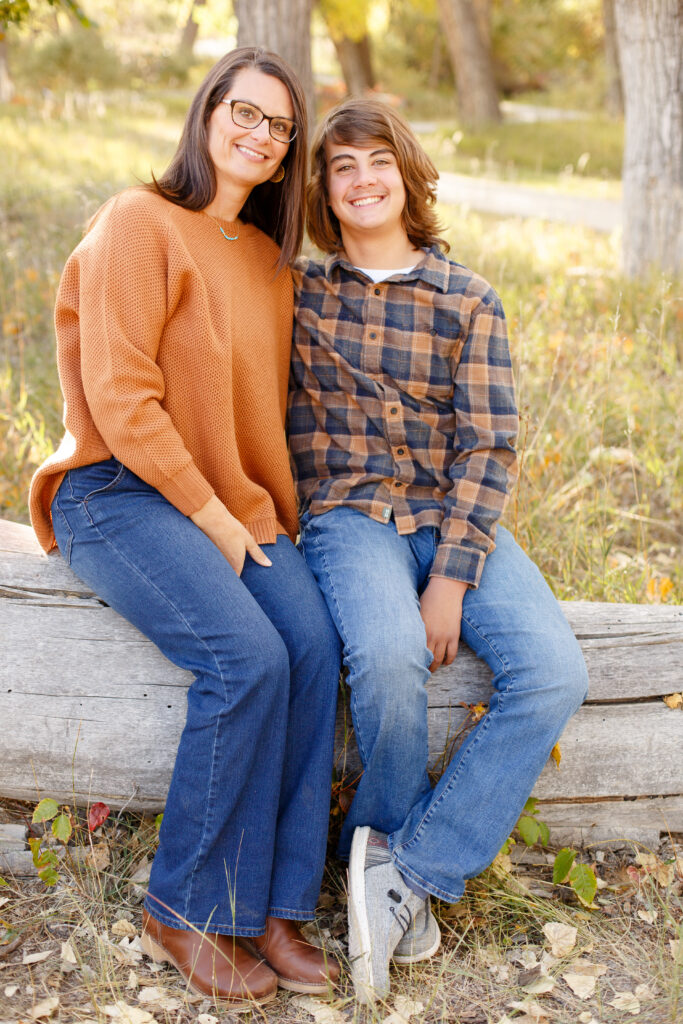 Mom and son sit on fallen log