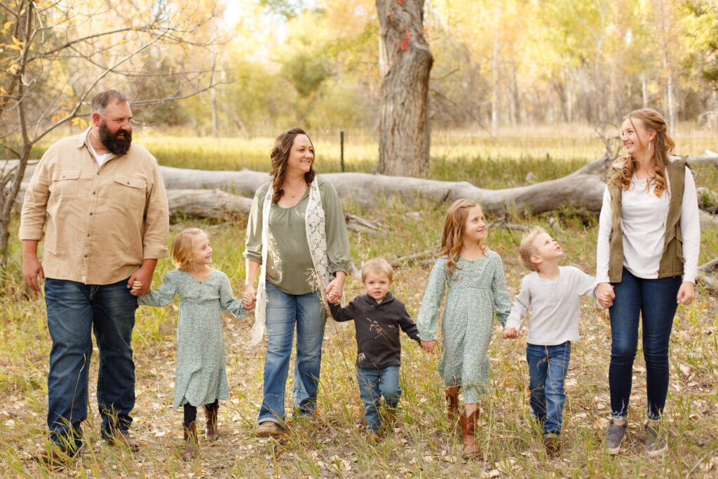 Family holds hands while walking in City Park