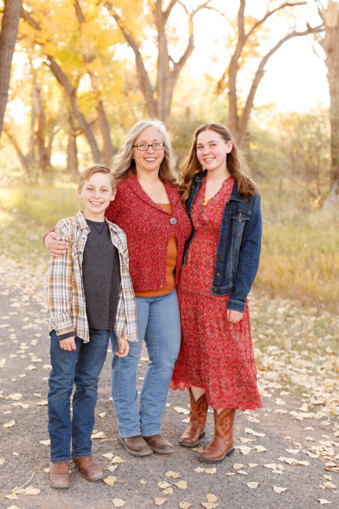 Mom and kids hug each other at fall family mini session in City Park, Pueblo CO