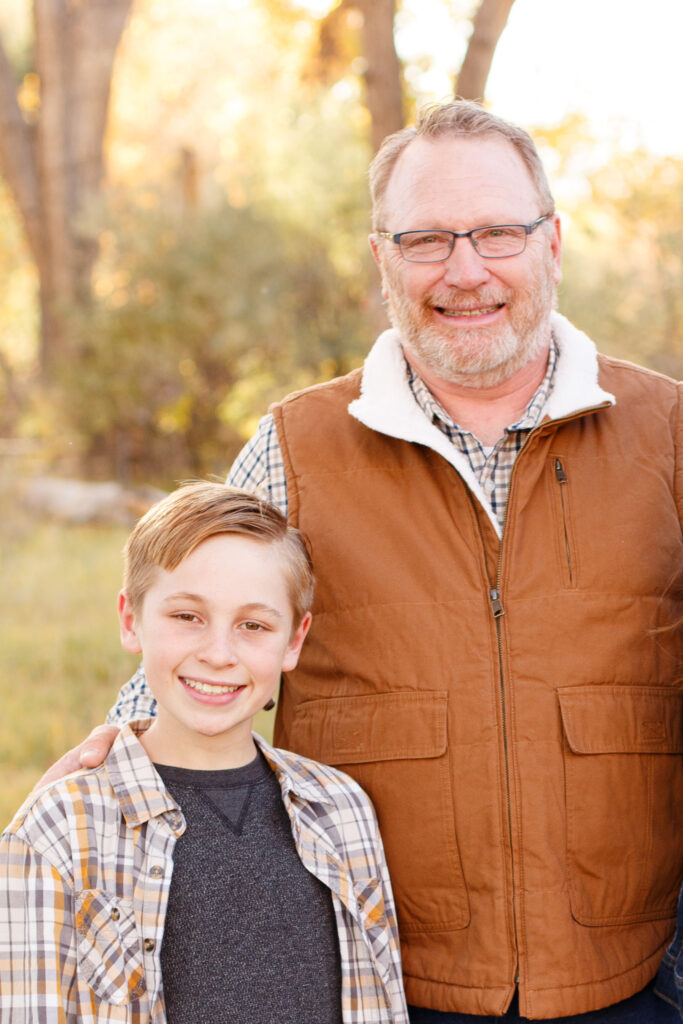 Dad and son smile at camera in City Park, Pueblo CO