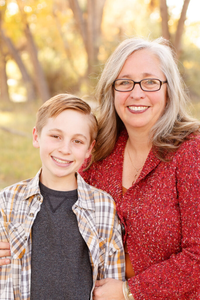 Mom and son smile in City Park, Pueblo CO at fall family mini session