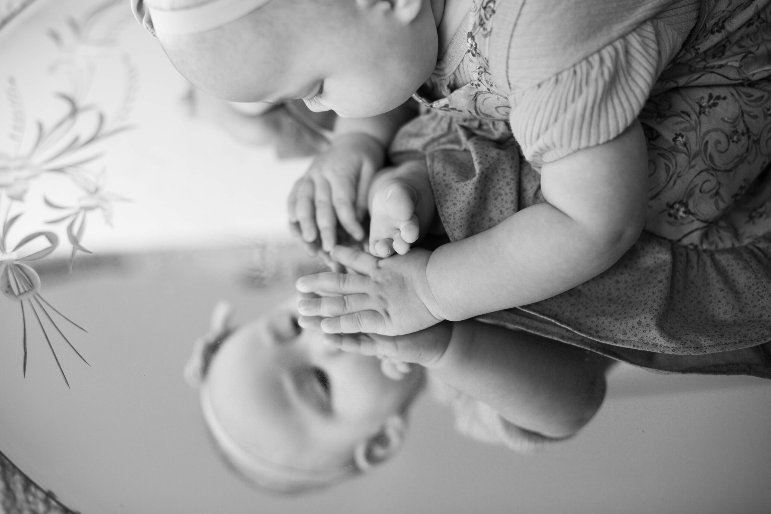 Baby touches her reflection in the mirror