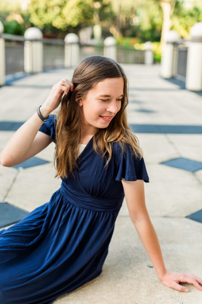 Girl tucks her hair behind her ear and smile.