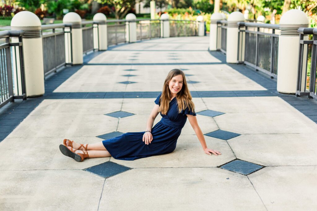 Girl is sitting on the ground and smiling at beautiful destination session in Orlando Florida.