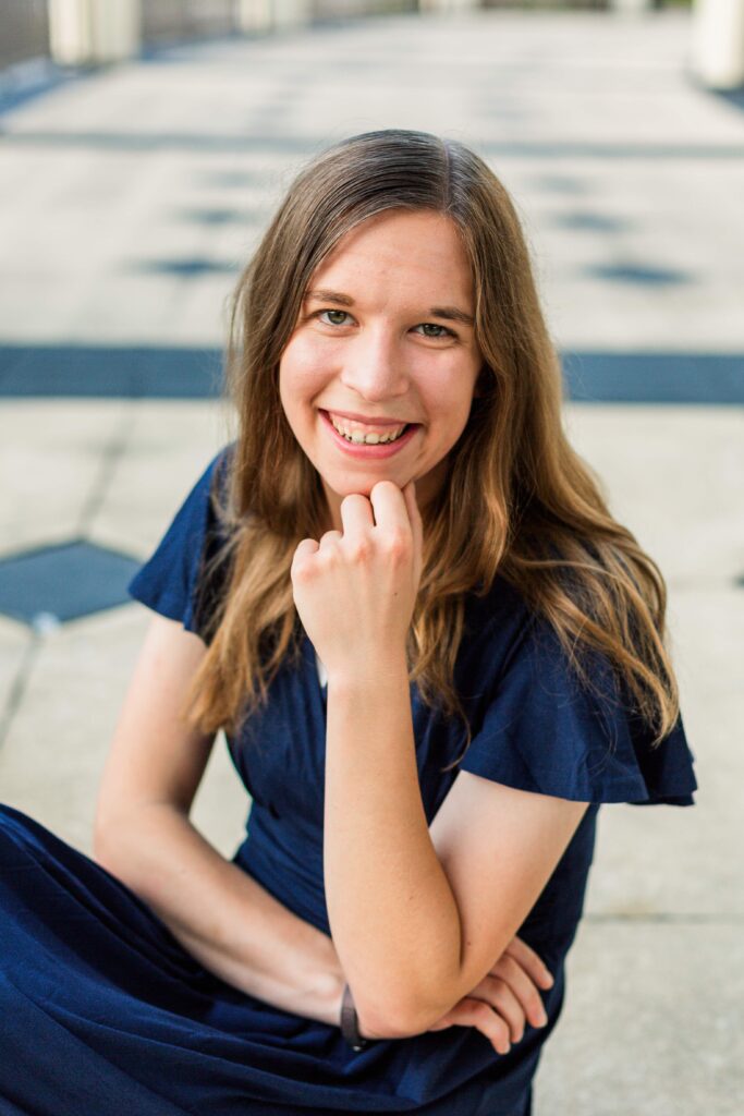 Girl sits on the ground and rests her chin on her hand at beautiful destination session in Orlando Florida.