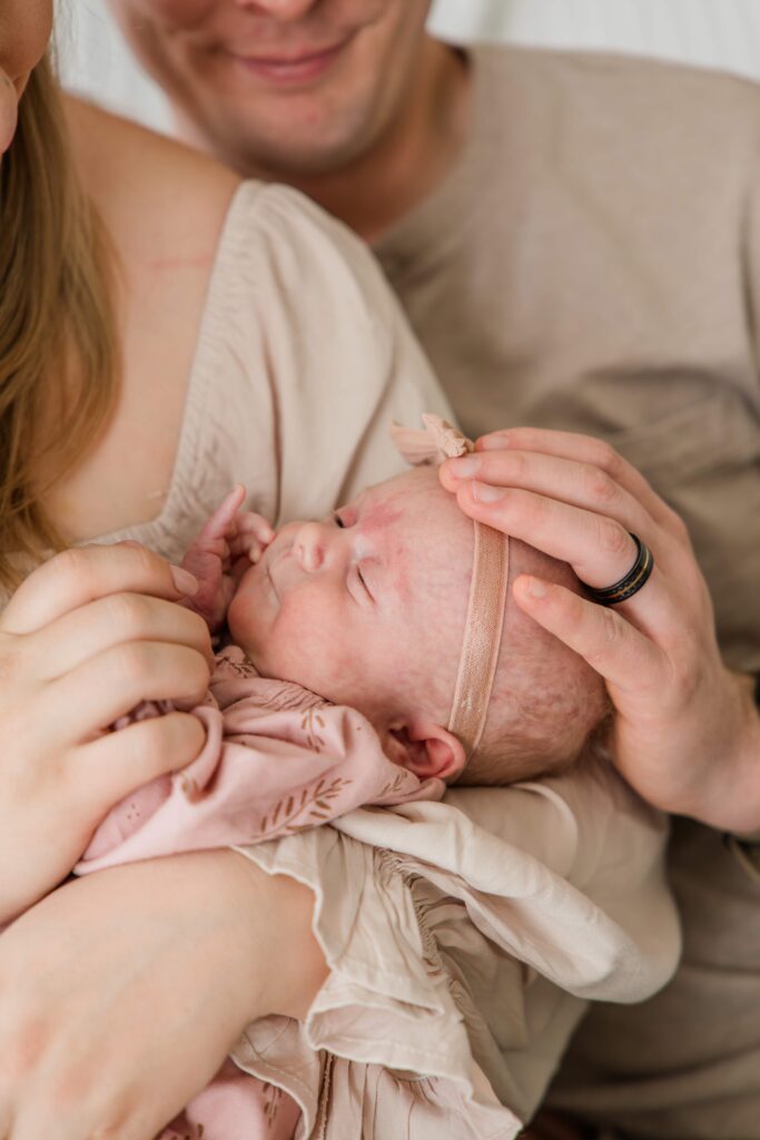 Dad gently cups baby's head with his hand