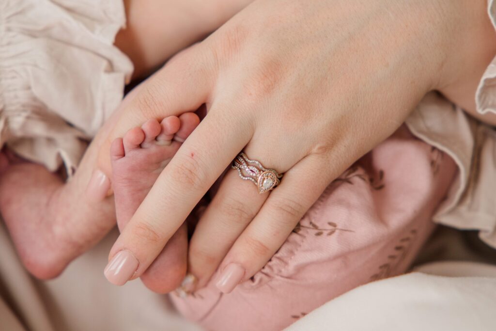 Detail shot of Mom's hand holding newborn's feet