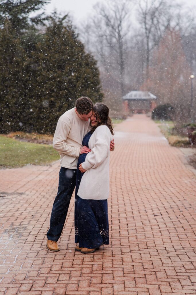 Husband rests hand on baby bump.