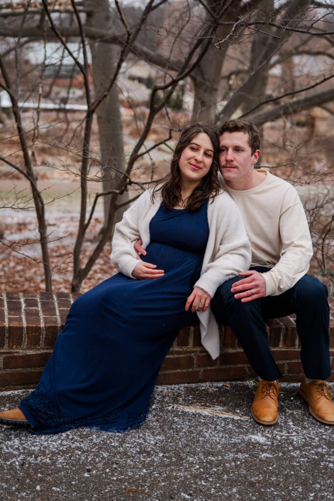 A couple sits on a low wall