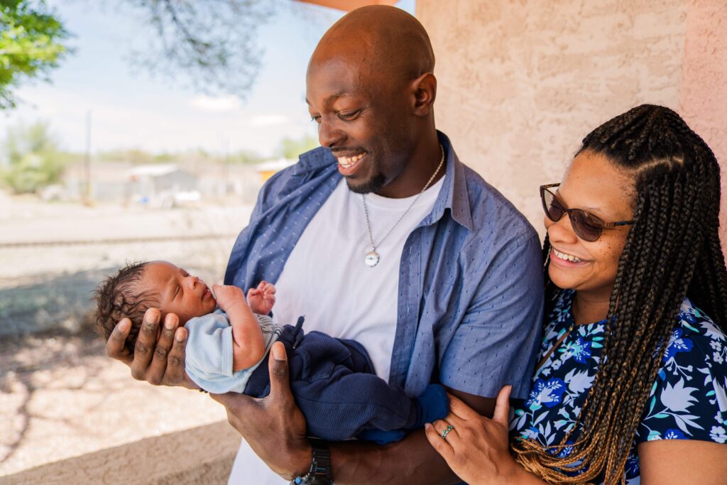 Dad and mom smile at baby