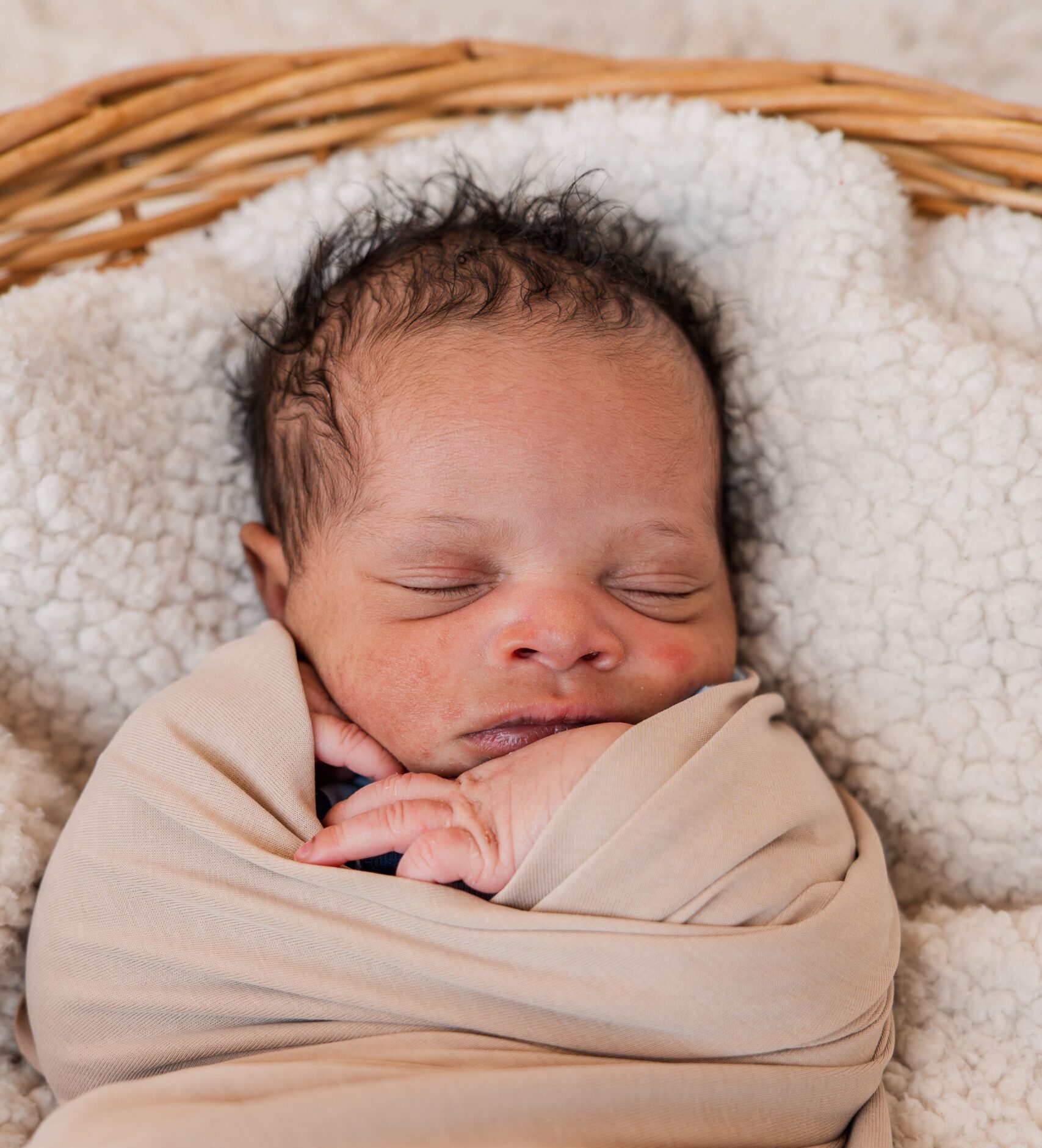 Baby is wrapped up and sleeps in basket