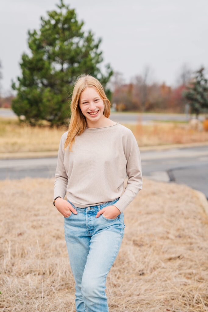 Girl stands with hands in pockets
