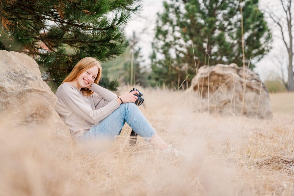 A girl rests her camera on knee