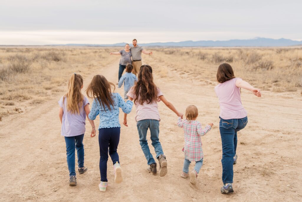 Dad and Mom hold out their arms and the kids run to them.