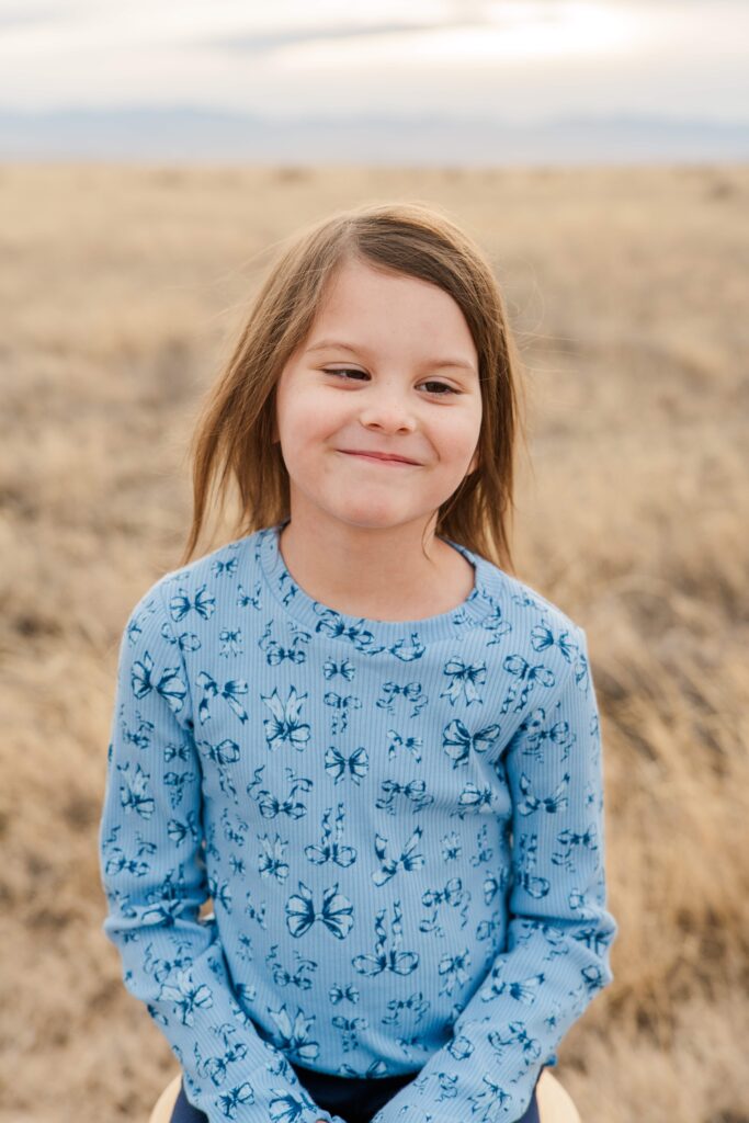 The third child smiles at the camera.
