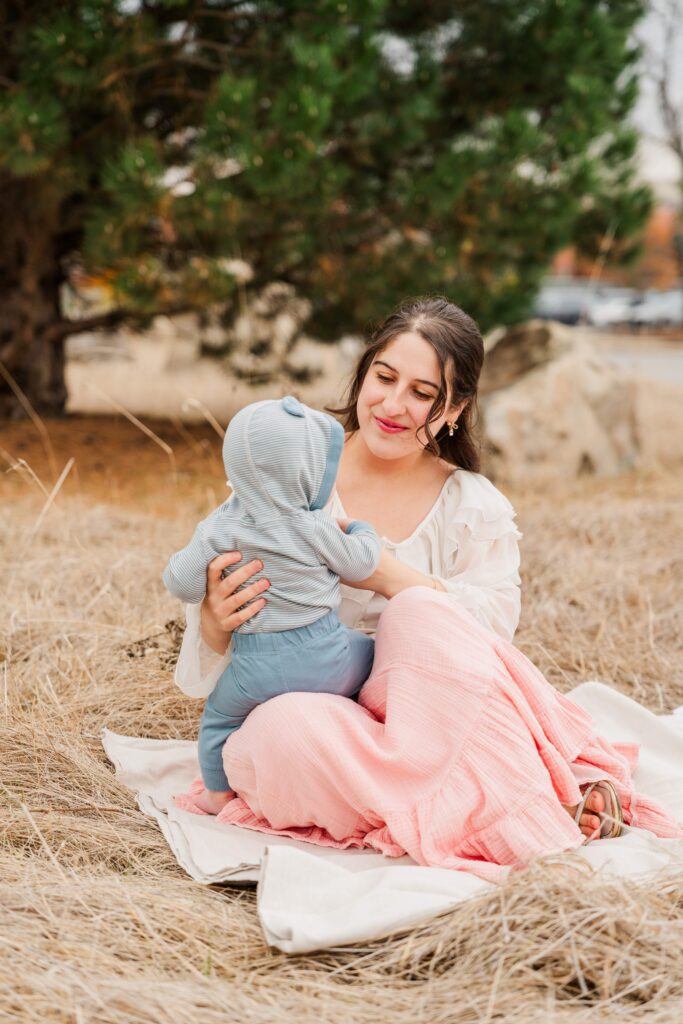 Mom plays with baby in her lap at mommy & me session.