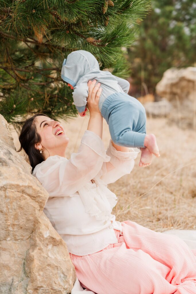 Mom holds baby up in the air.