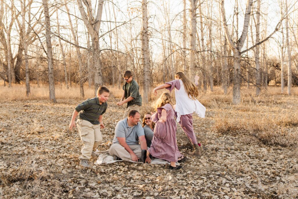 Kids run around parents sitting on the ground.