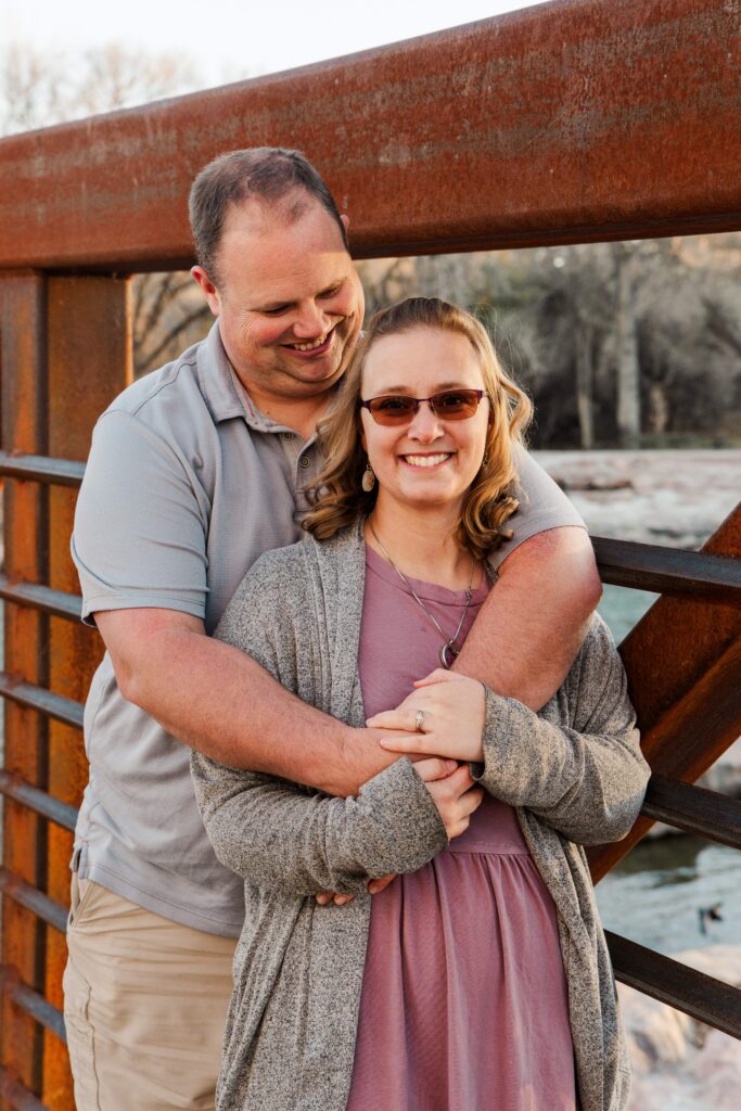 Husband hugs his wife and looks at her.