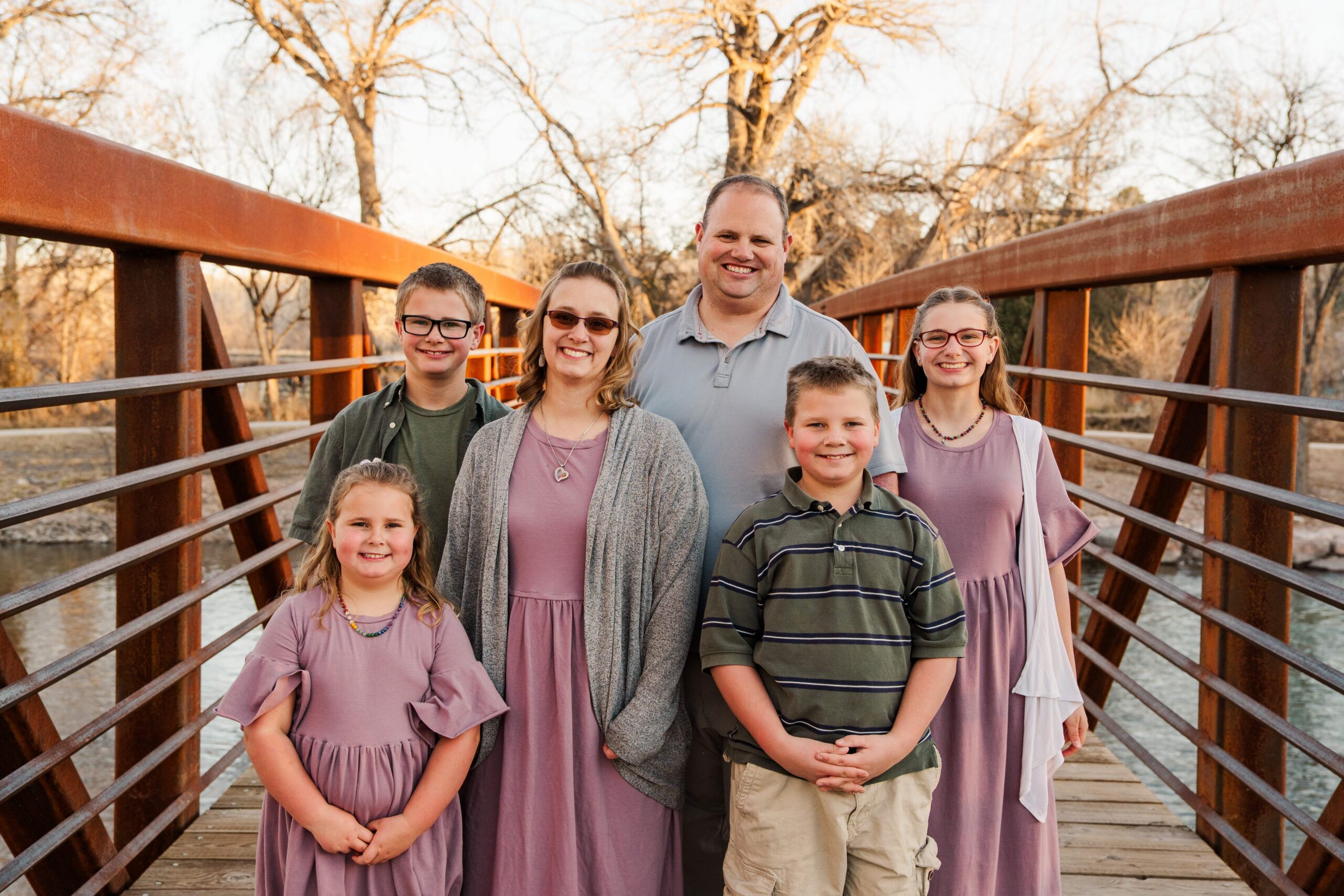 Family stands on the bridge and smile.