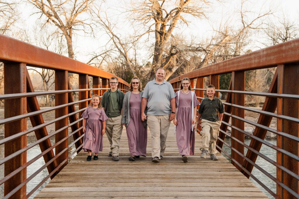 Family walks down the bridge for their session with Pueblo CO Family Photographer