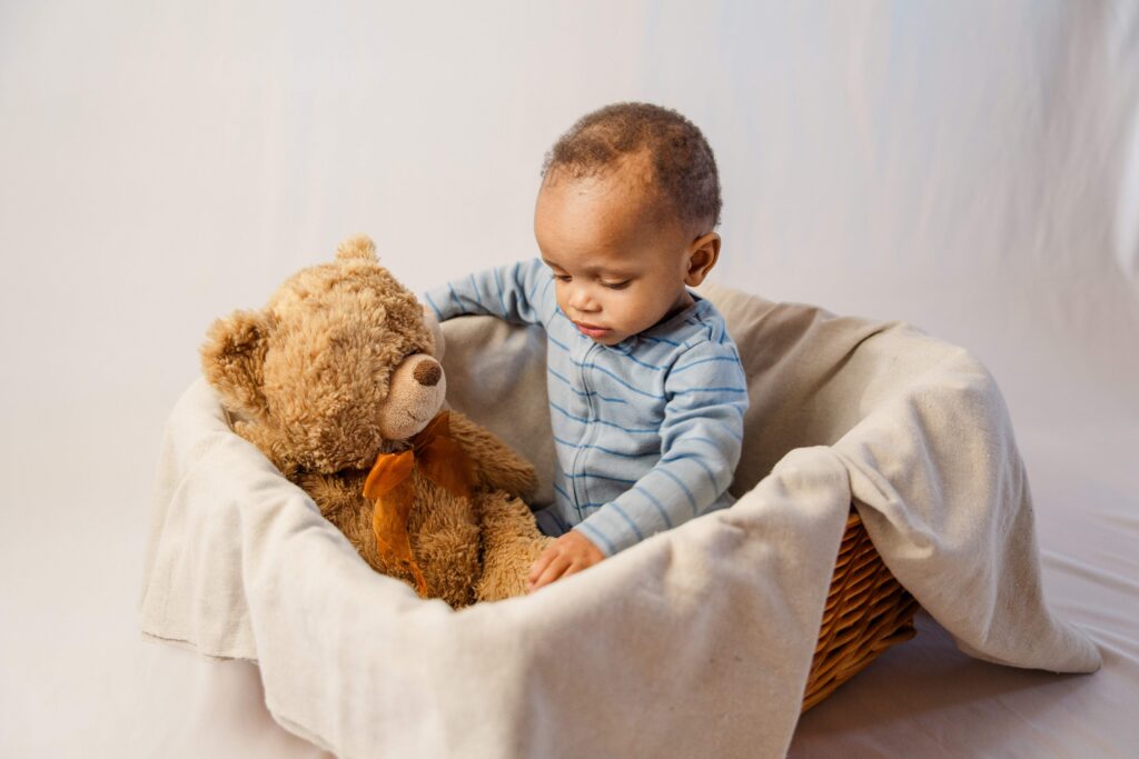 Baby has a teddy bear and is touching its toes