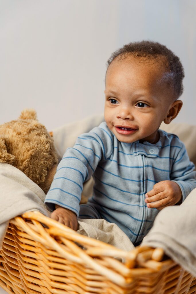 Baby and a teddy bear sit in a big basket