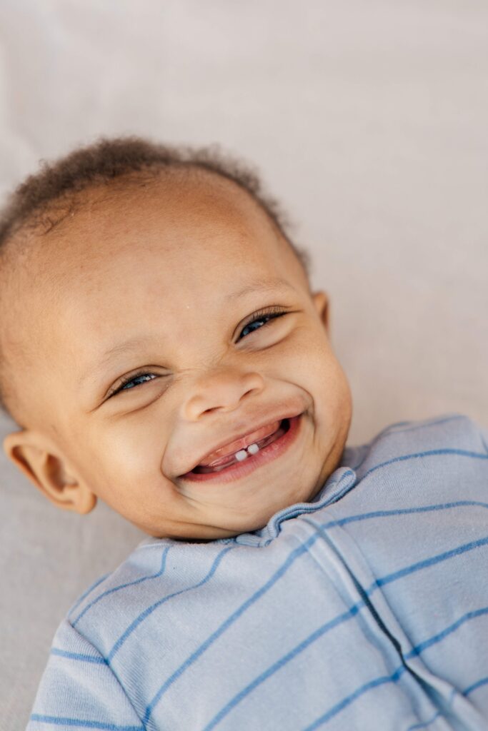 Baby lays on the ground and laughs